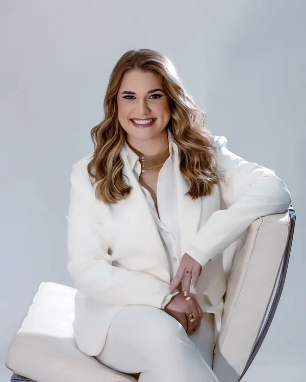 Retrato da Dra. Lara Gimenez sentada, vestindo branco